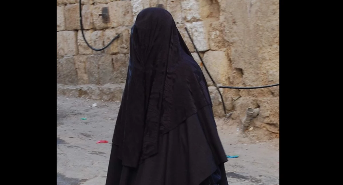 Pòzdrzatkòwi òdjimk. Aùtór: Zivya; zdrzódło: https://pl.wikipedia.org/wiki/Burka#/media/Plik:A_female_member_of_the_Haredi_burqa_sect_in_Mea_Shearim.jpg
